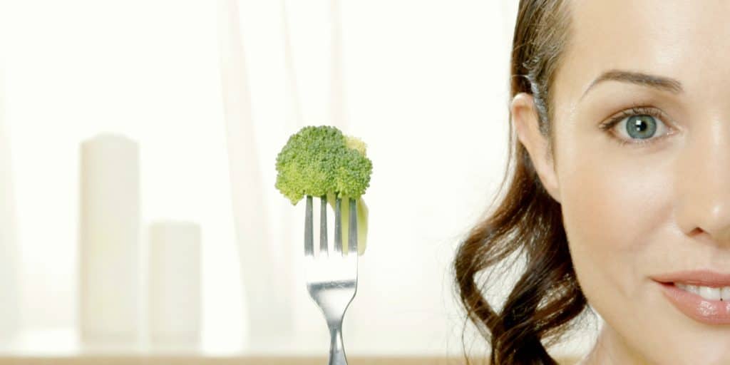 woman holding broccoli on fork - Campus dentist